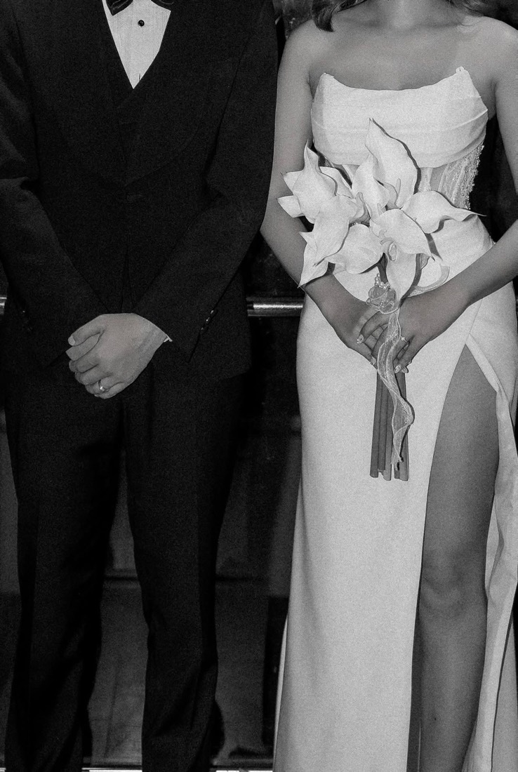 Bride holding a calla bouquet beside her groom, black and white